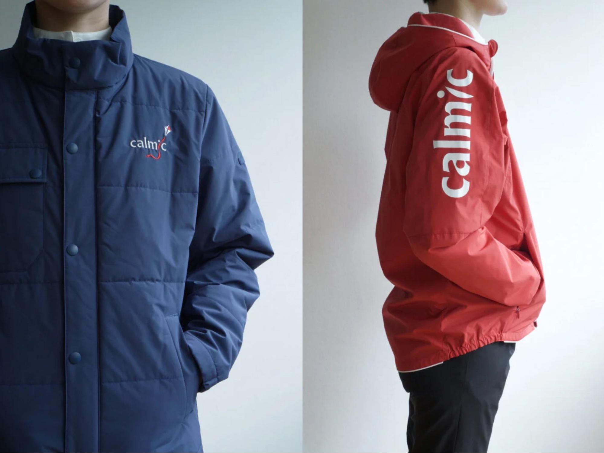 ネイビーと赤のロゴ入りブルゾンを着用している男性