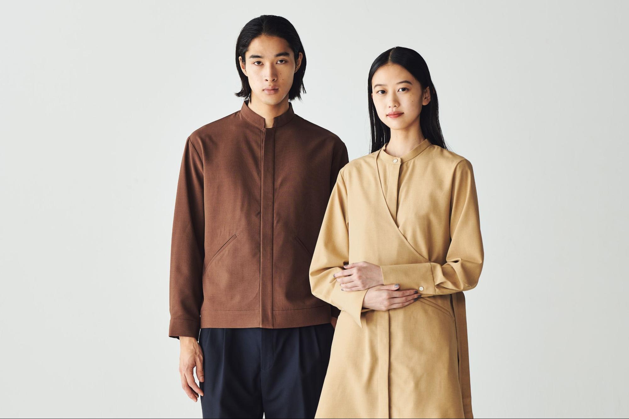 ブラウンと黒のユニフォームを着用した男性スタッフとベージュのユニフォームを着用した女性スタッフ