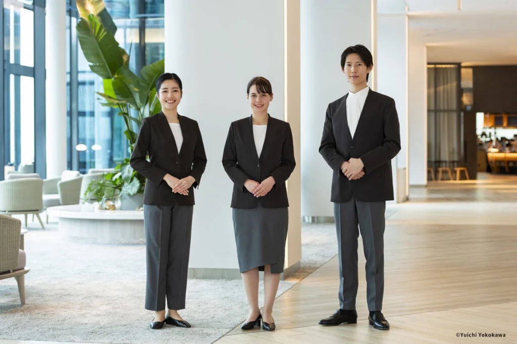 アースブラウンの制服を着用した3名のホテルスタッフ