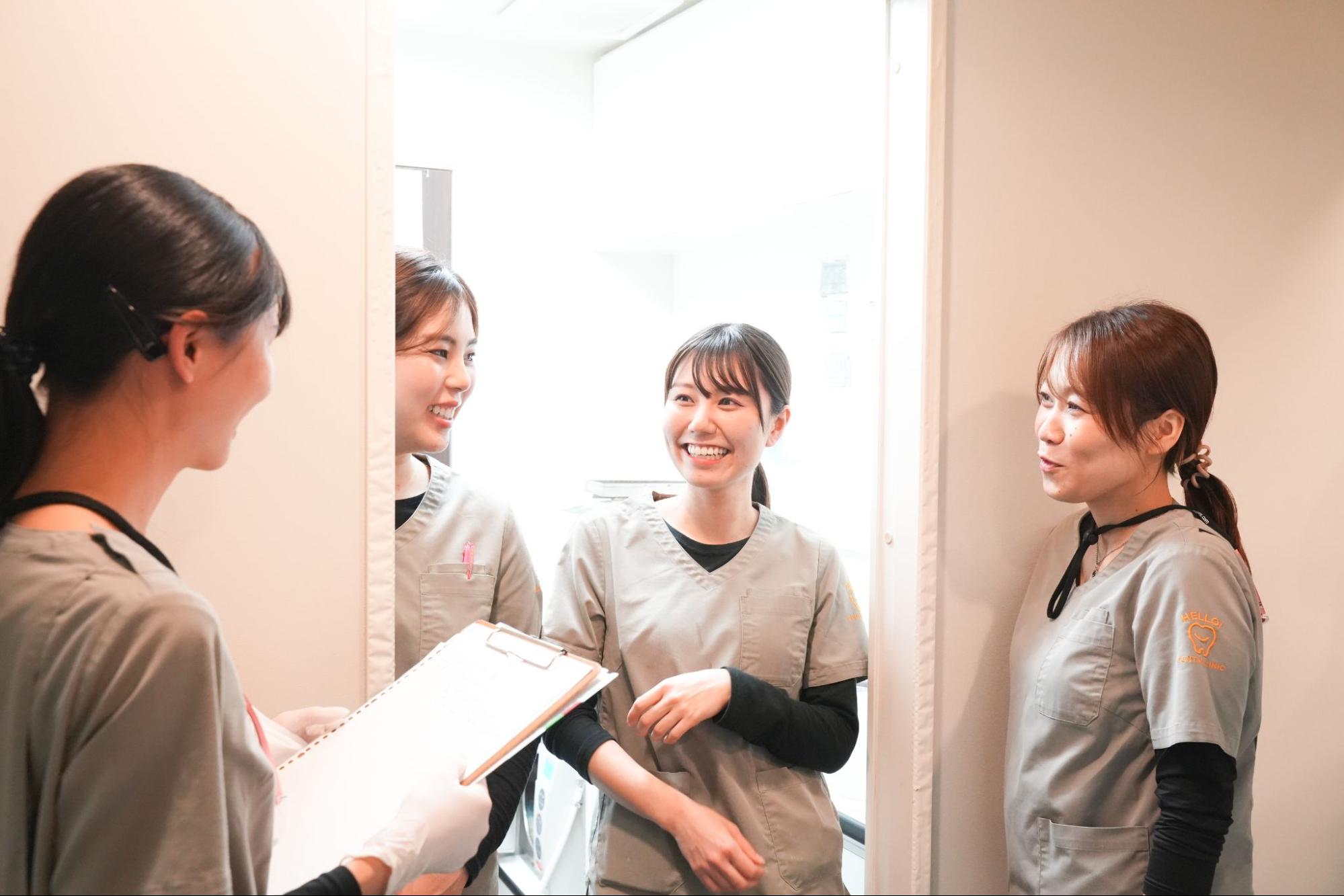 グレーのスクラブを身につけた医療従事者が歓談する様子